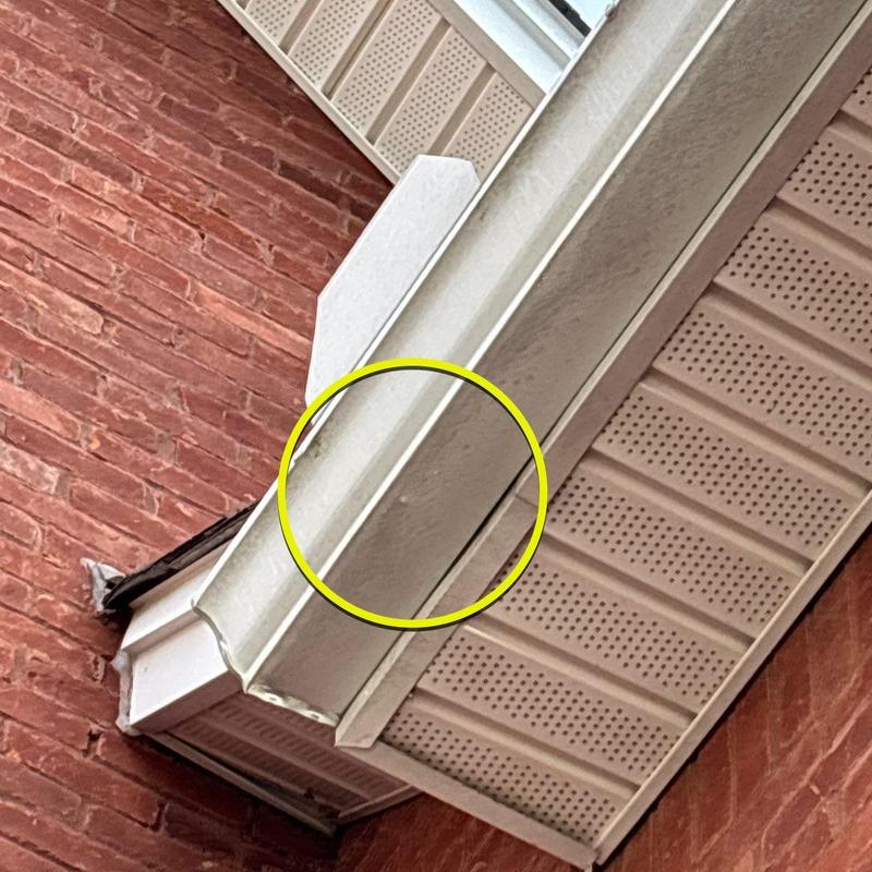 Gutter with dented section near soffit and fascia