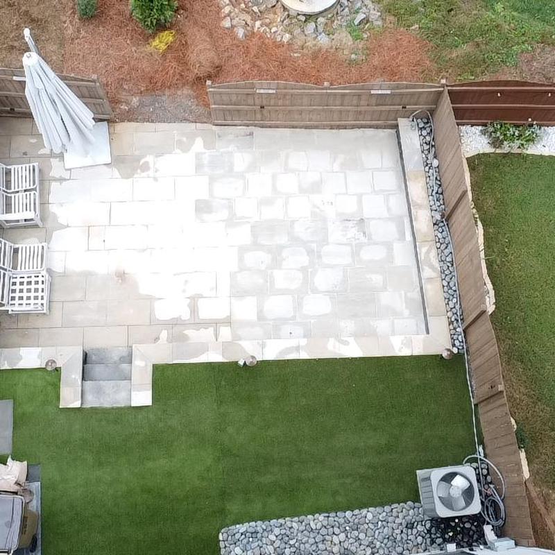 Paver patio with surrounding landscaping and lighting