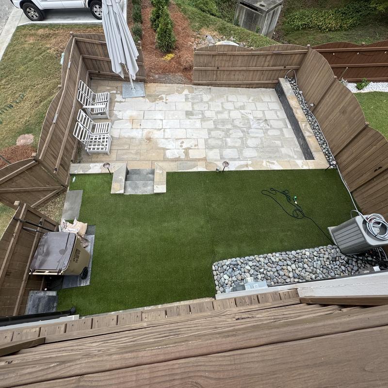 Outdoor paver patio with artificial turf and lighting