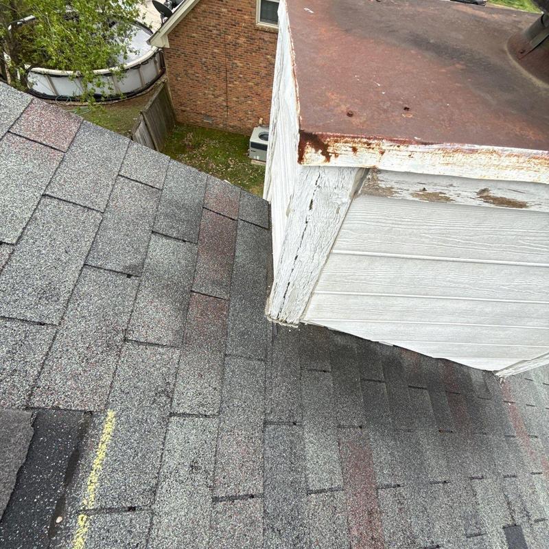 Roof shingles with hail damage near chimney cap