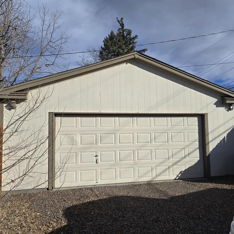 Detached garage roof with worn shingles and gutters Detached garage roof with worn shingles and gutters