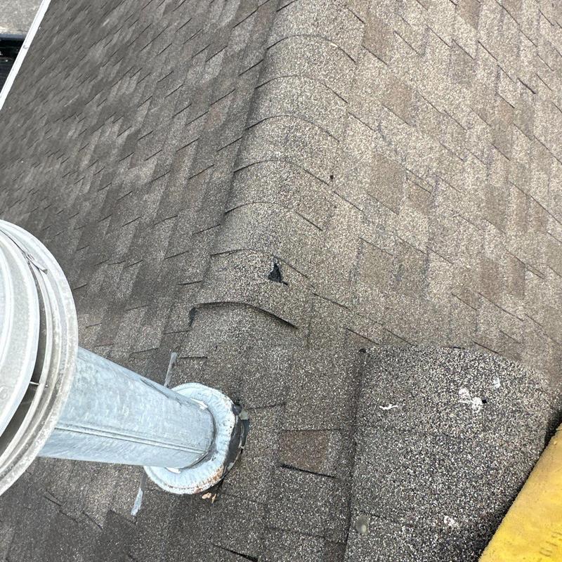 Roof shingles with hail damage near metal vent pipe