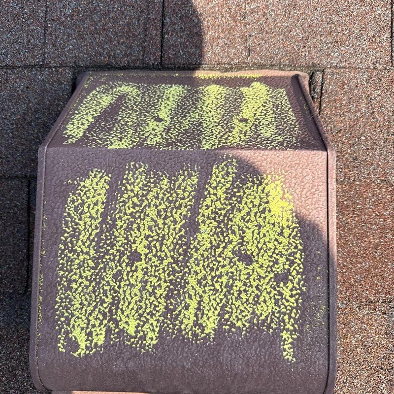 Roof vent with hail damage markings on shingles