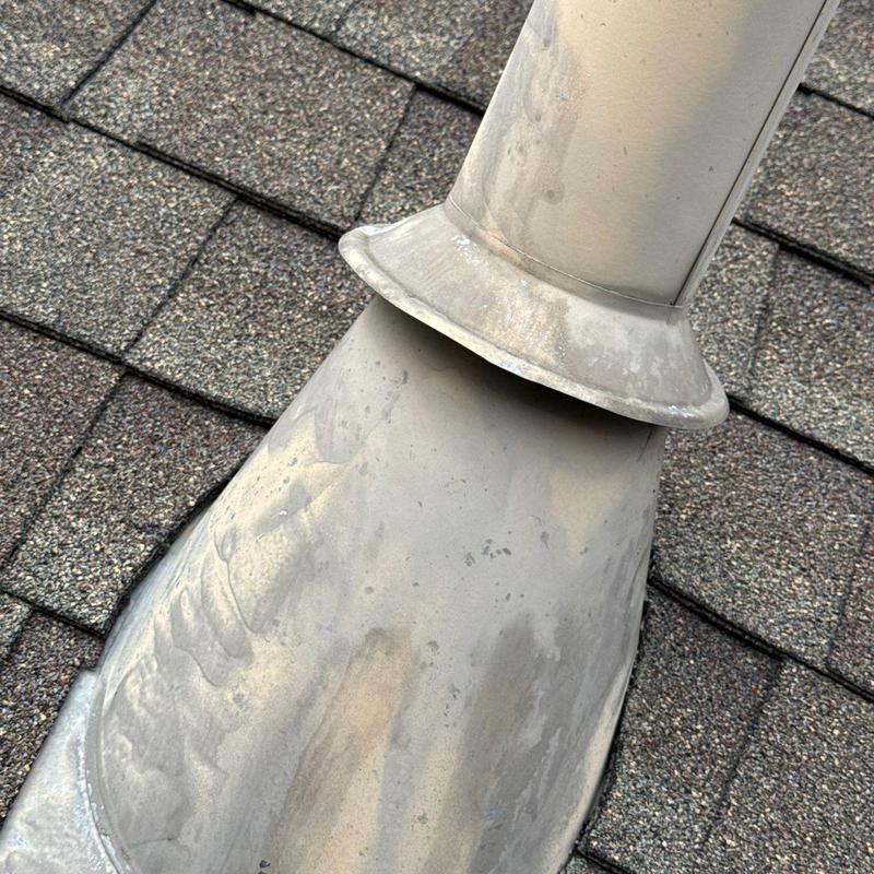 Roof vent flashing on shingle roof with weathering marks