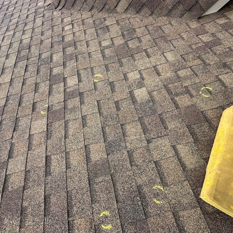 Asphalt shingle roof with marked hail damage spots