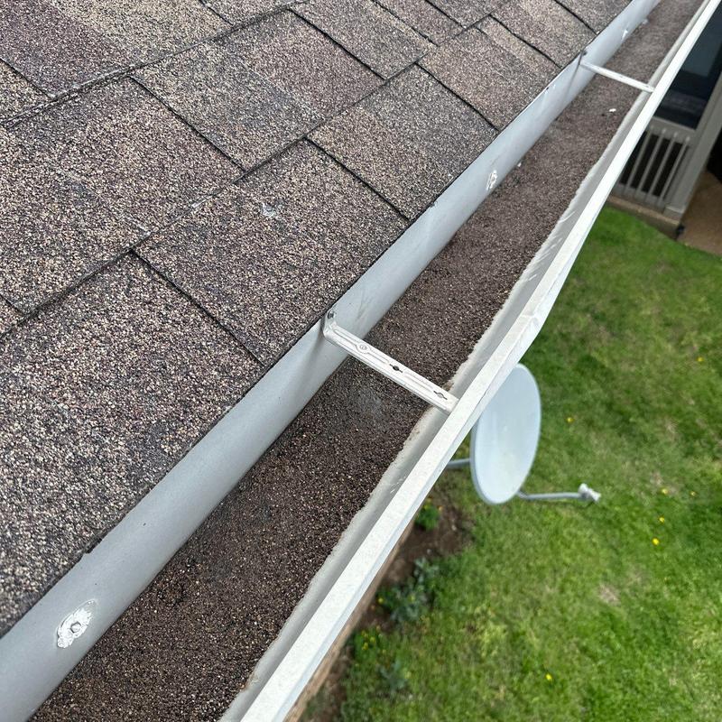Asphalt shingle roof and gutter with hail damage