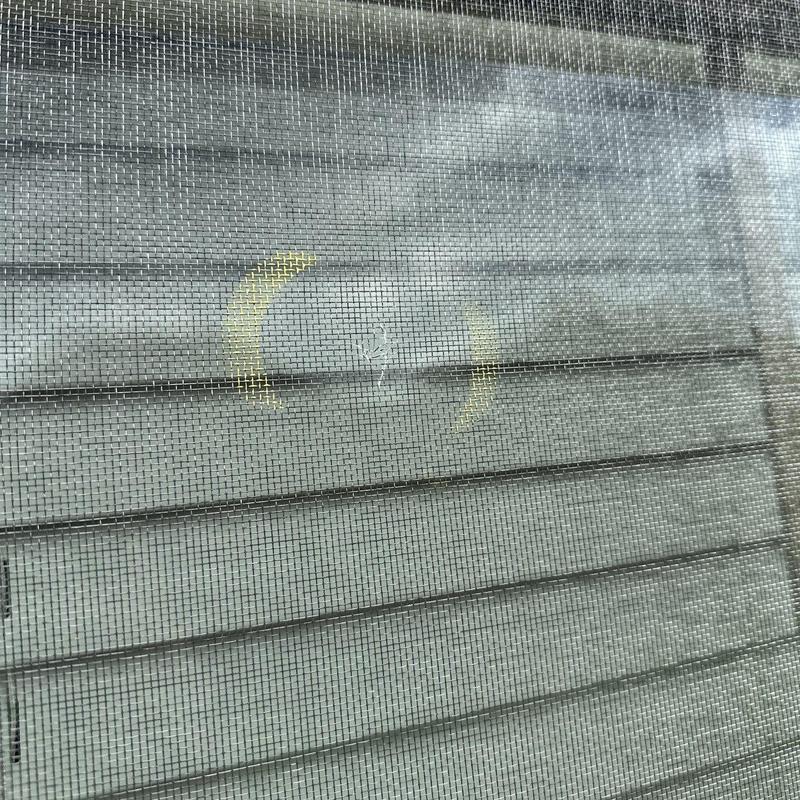 Window screen mesh with small damage marked in yellow