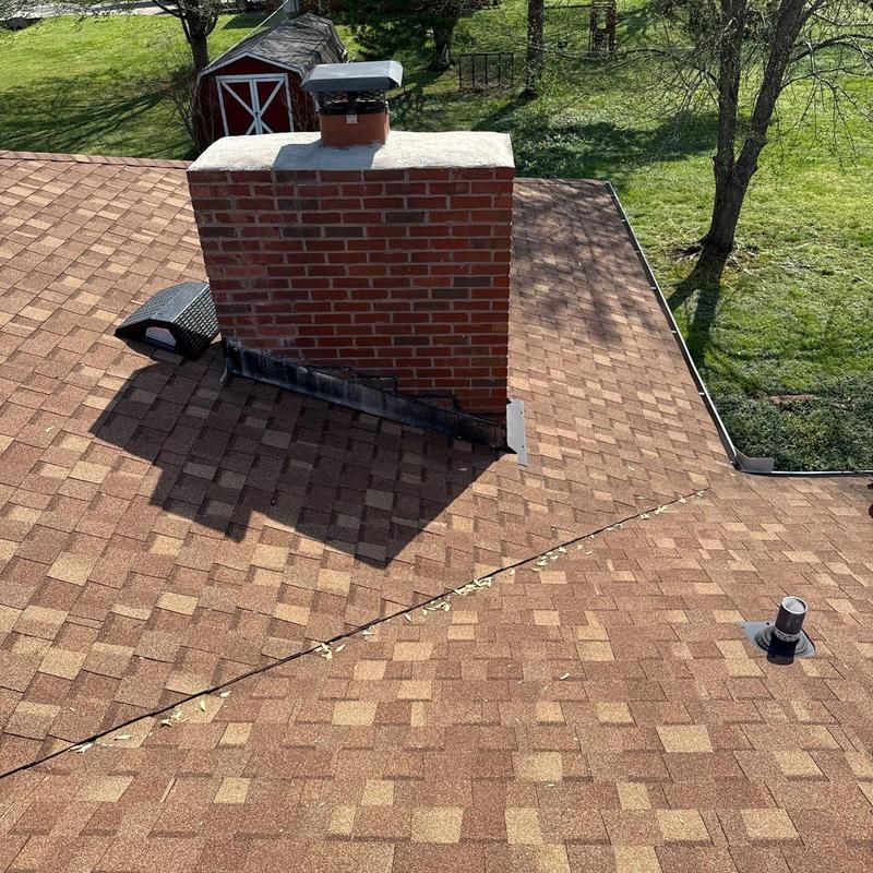 Roof shingles and chimney flashing inspection on brown roof