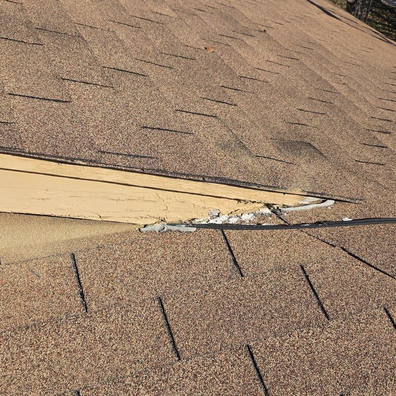 Roof shingles with hail damage near roof edge trim