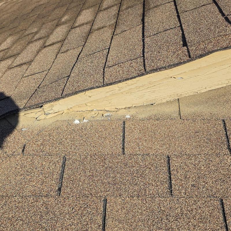 Roof shingles with hail damage near wood trim