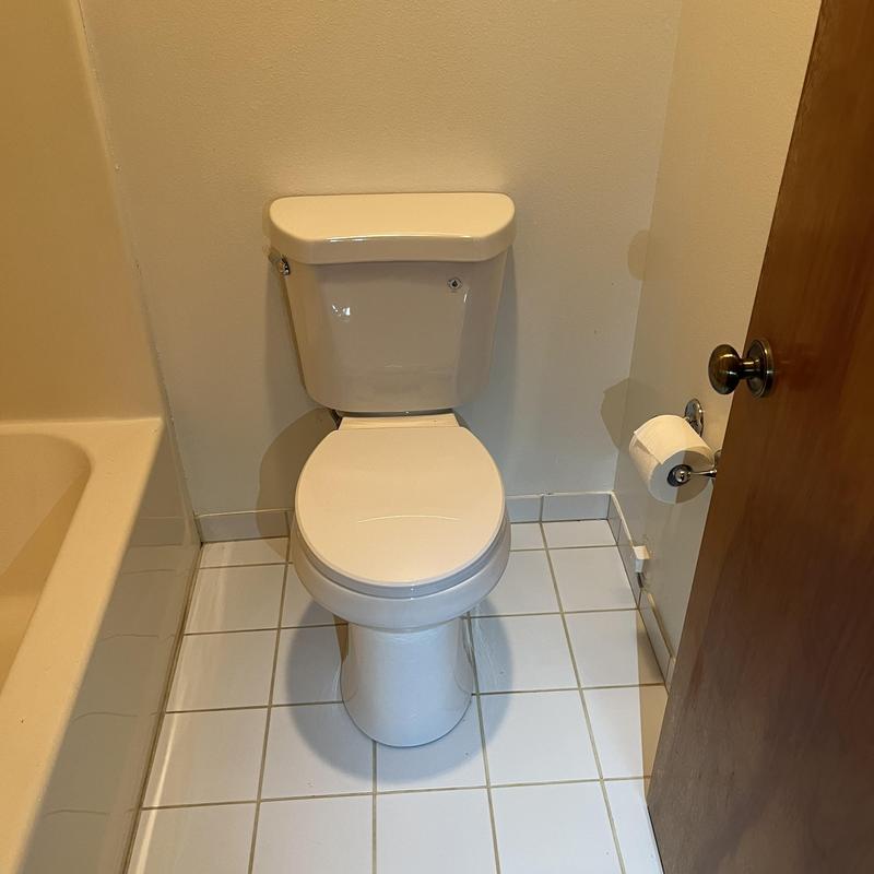 Toilet installation in tiled bathroom corner