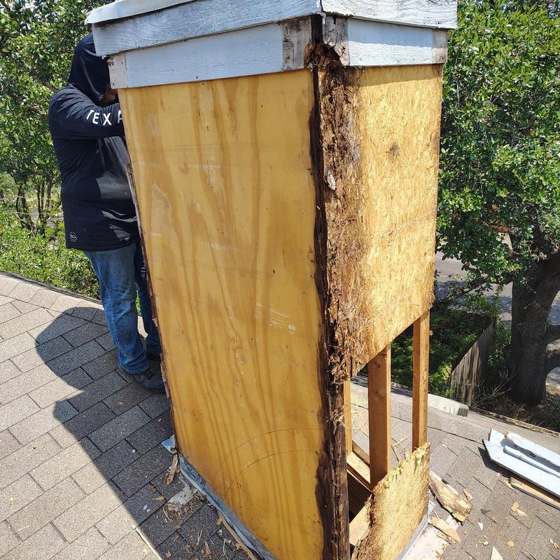 Chimney with rotted plywood and damaged siding on roof