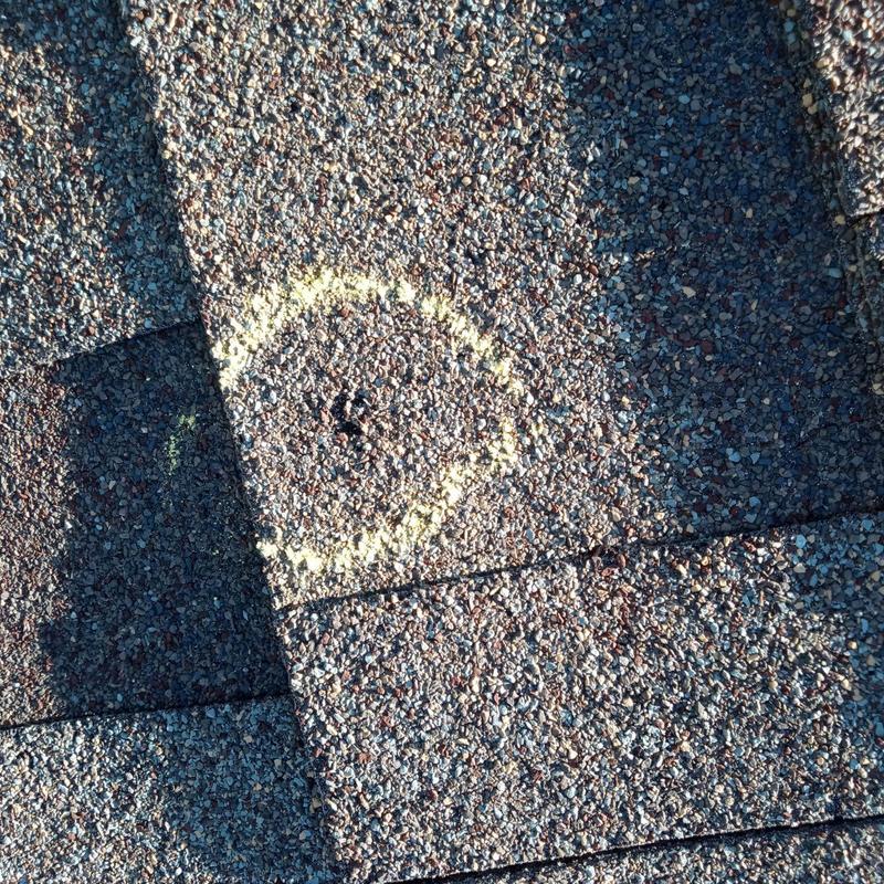 Asphalt roof shingle hail damage marked with chalk Asphalt roof shingle hail damage marked with chalk