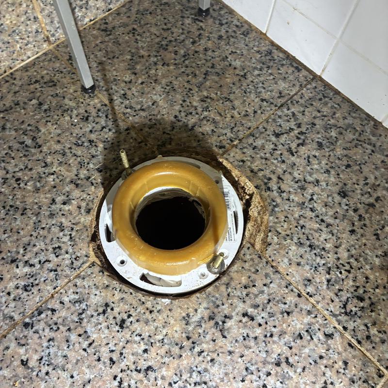 Toilet flange with new wax ring installed on tile floor