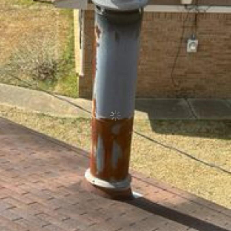 Metal roof vent pipe with rust on shingle roof