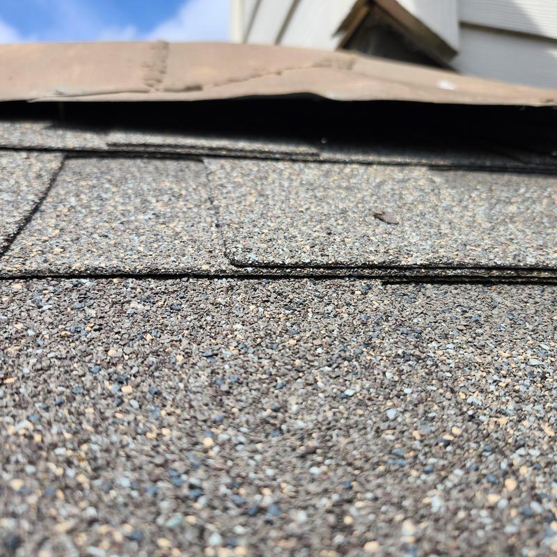 Turnback flashing and ridge shingles on roof edge