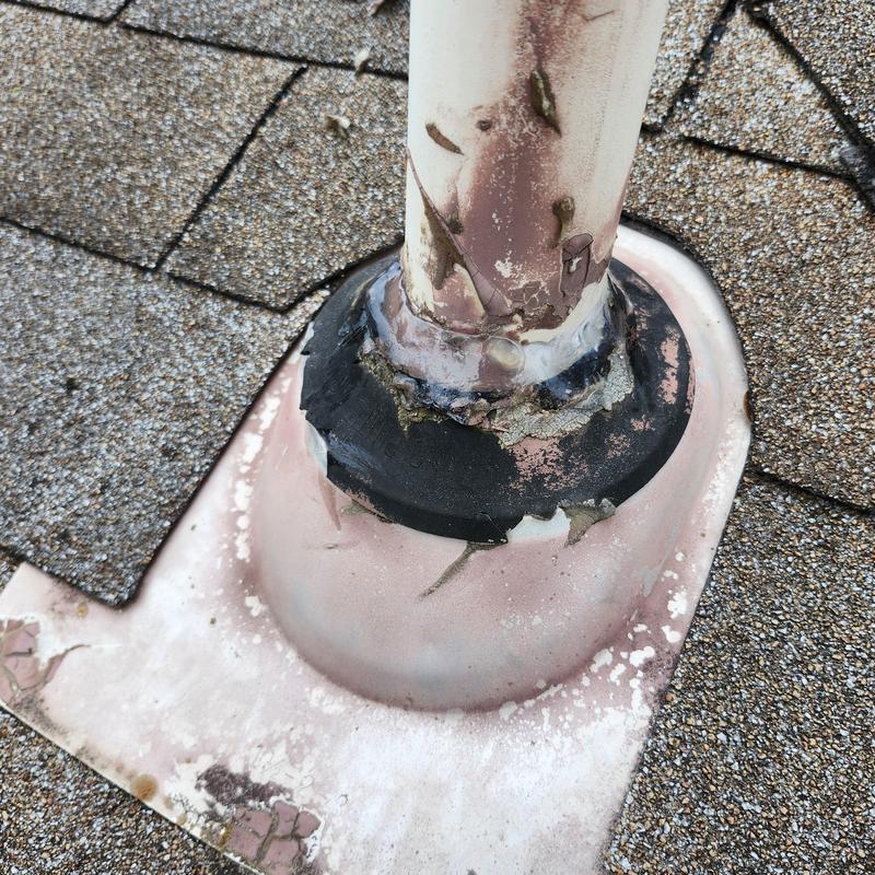 Plumbing boot with cracked and caulked seal on shingle roof