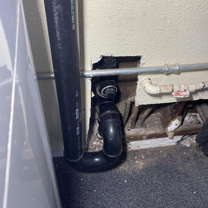 Laundry drain pipe with wall access hole and surrounding pipes