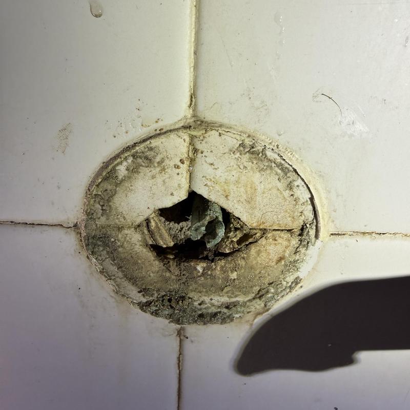 Bathtub overflow drain with deteriorated seal and tile grout