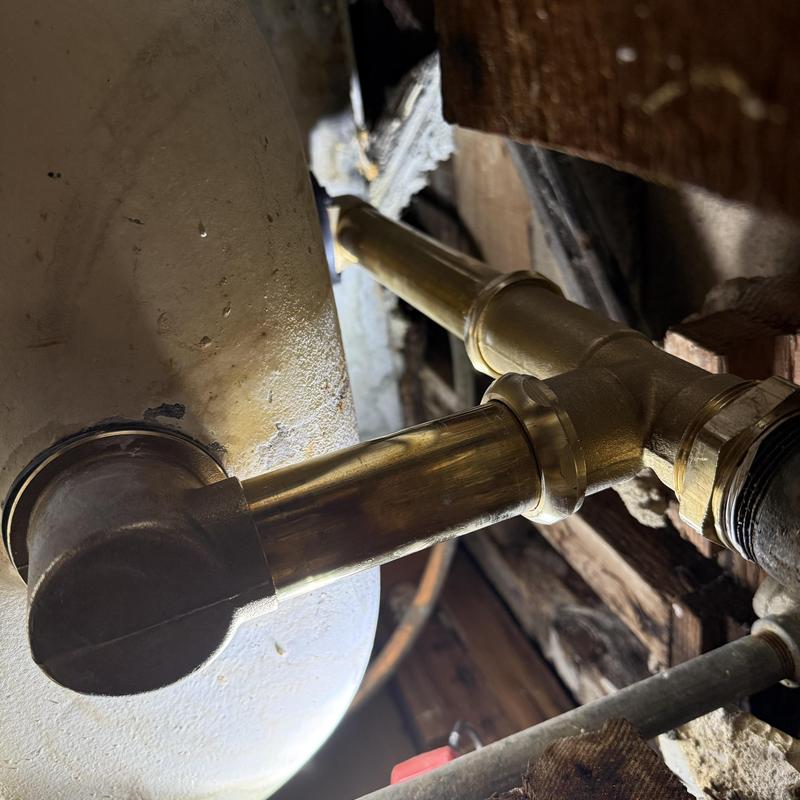 Brass tub waste and overflow pipes installed beneath tub