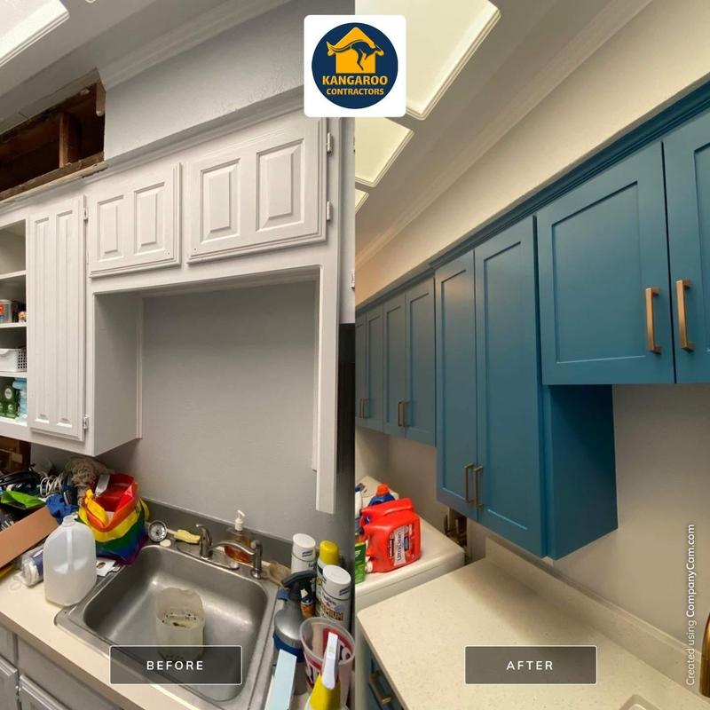 Blue painted laundry room cabinets with brass handles