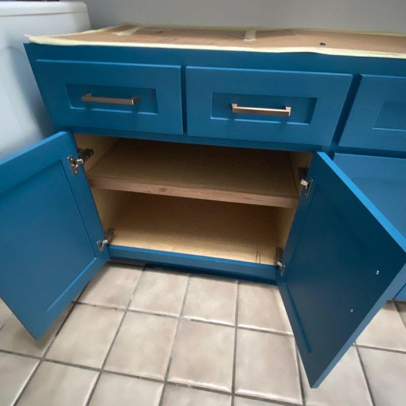 Laundry room cabinets with clear coat interior and brass handles