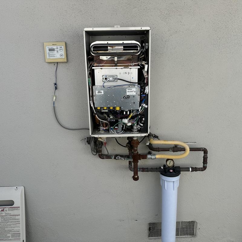 Tankless water heater with exposed heat exchanger and piping