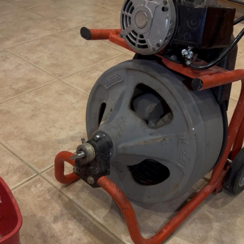 Kitchen drain snake machine on tile floor
