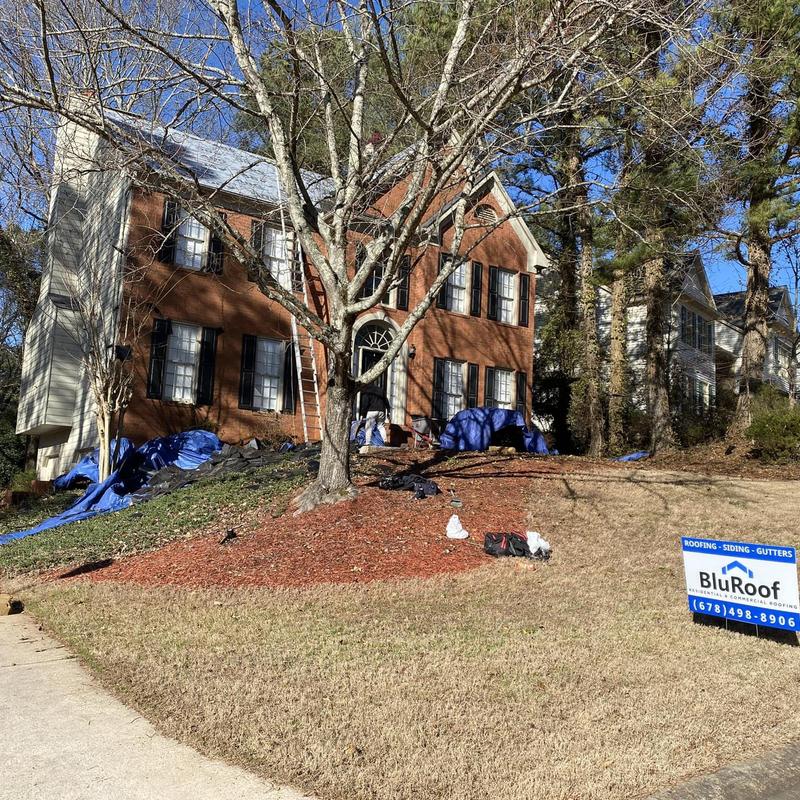Roof shingles replacement on brick two-story house