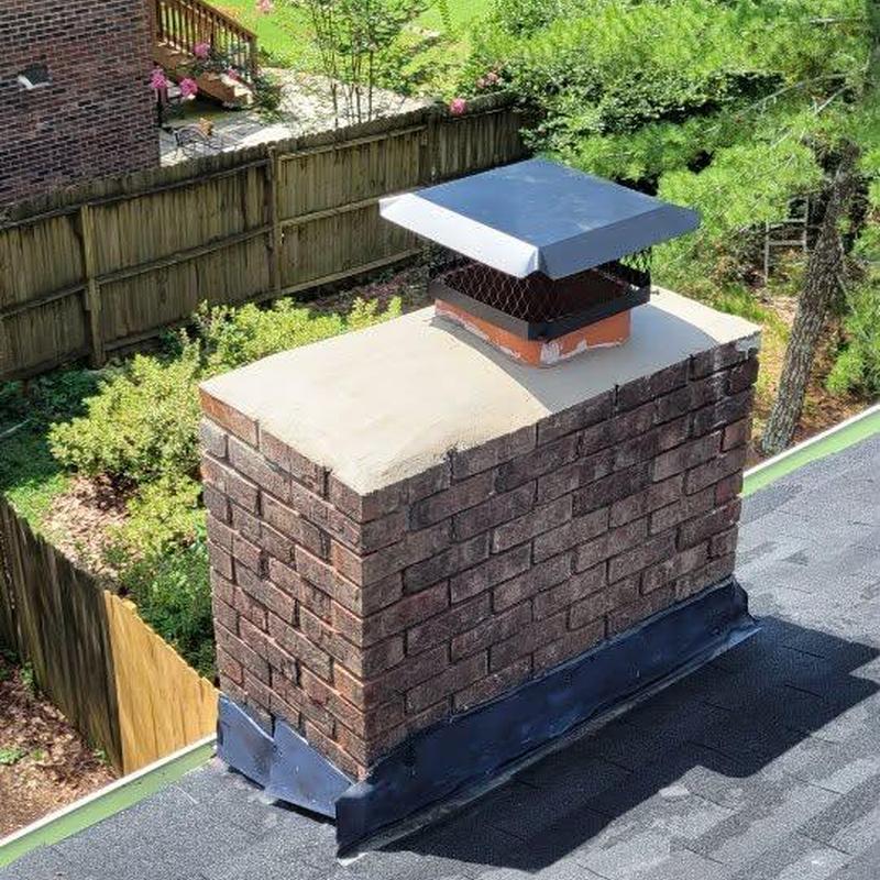 Brick chimney with metal chimney cap and roof flashing Brick chimney with metal chimney cap and roof flashing