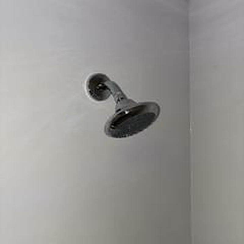Standard shower head and arm installation in bathroom