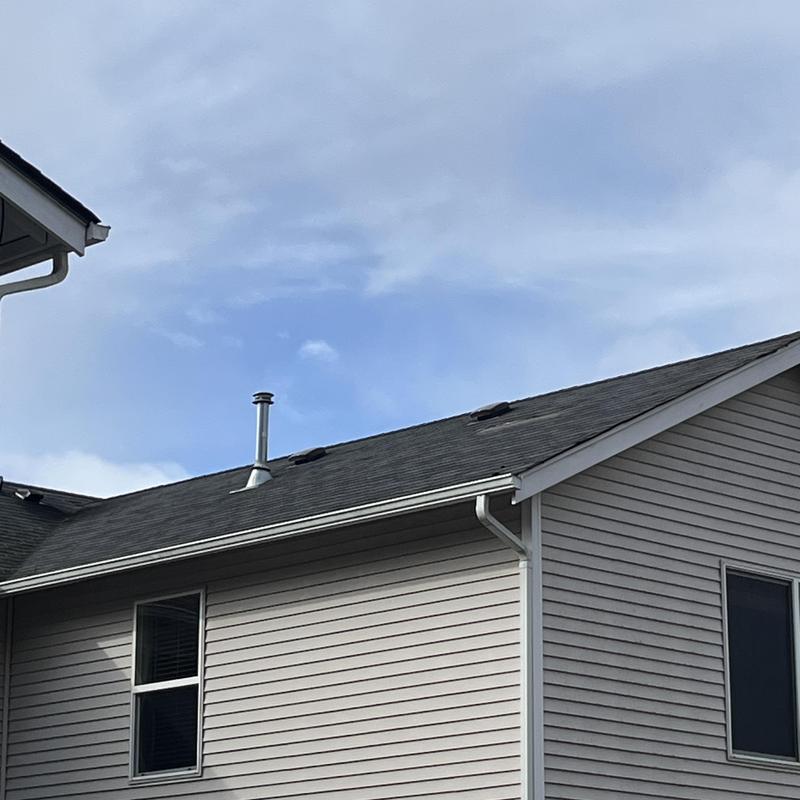 Roof shingles missing from wind storm damage on house roof Roof shingles missing from wind storm damage on house roof
