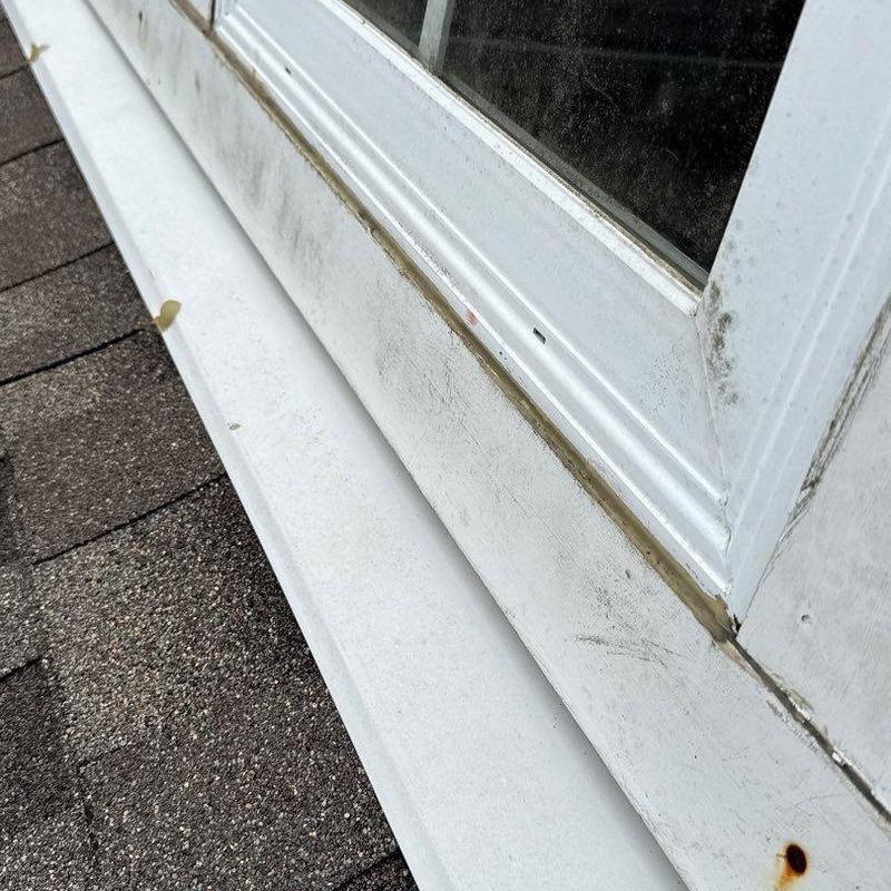 Window flashing with rust and sealant wear on roof edge