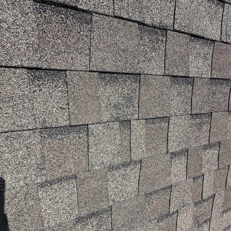 Asphalt shingle roofing with hail damage close-up