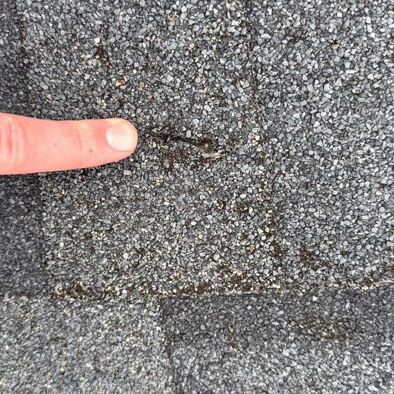 Asphalt shingle surface with hail damage close-up