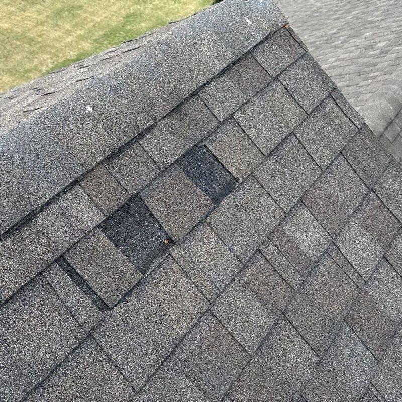 Asphalt shingles with hail damage on roof ridge area