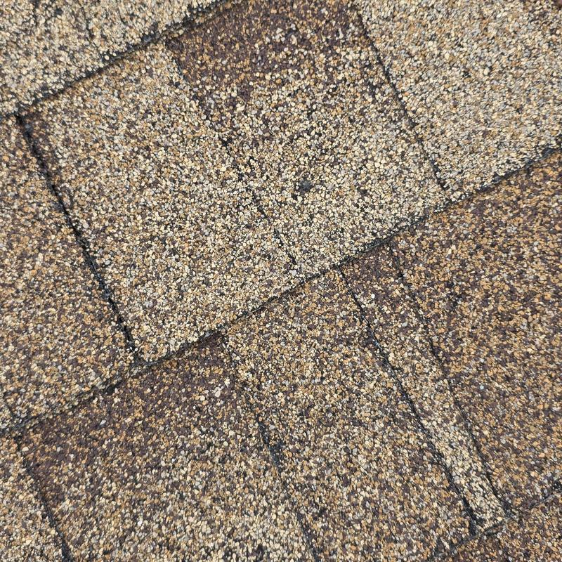 Asphalt roof shingles with hail damage close-up