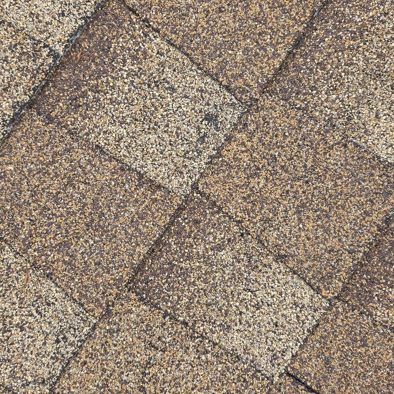 Asphalt roof shingles with hail impact damage