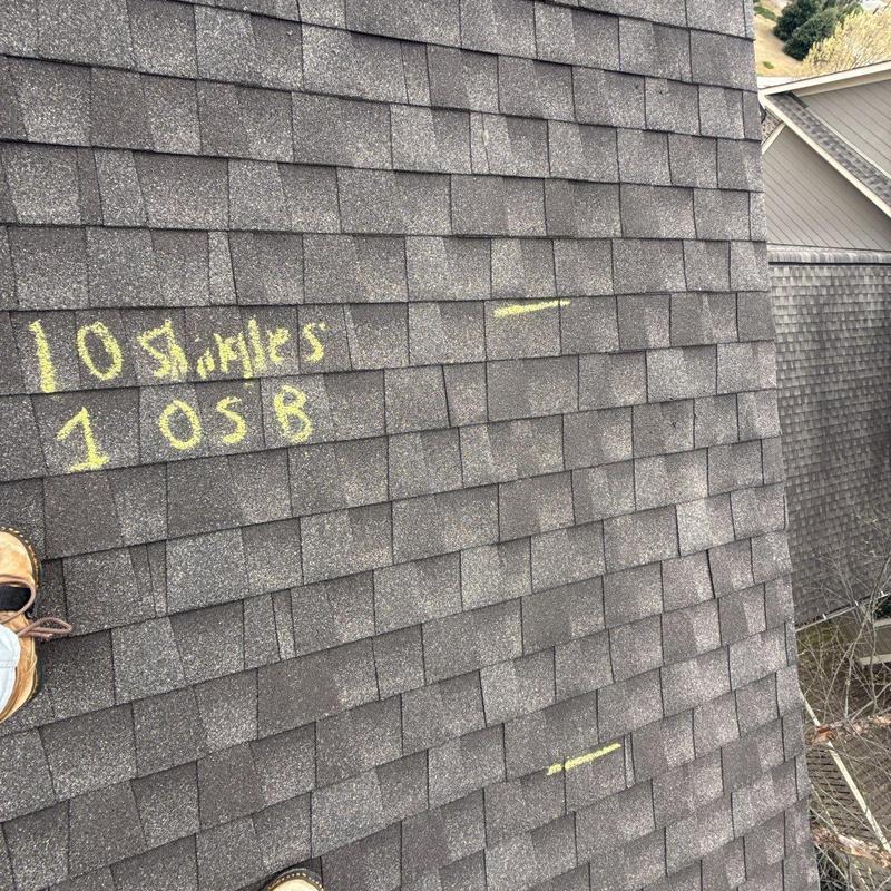 Shingle roof with yellow chalk markings for damage counts