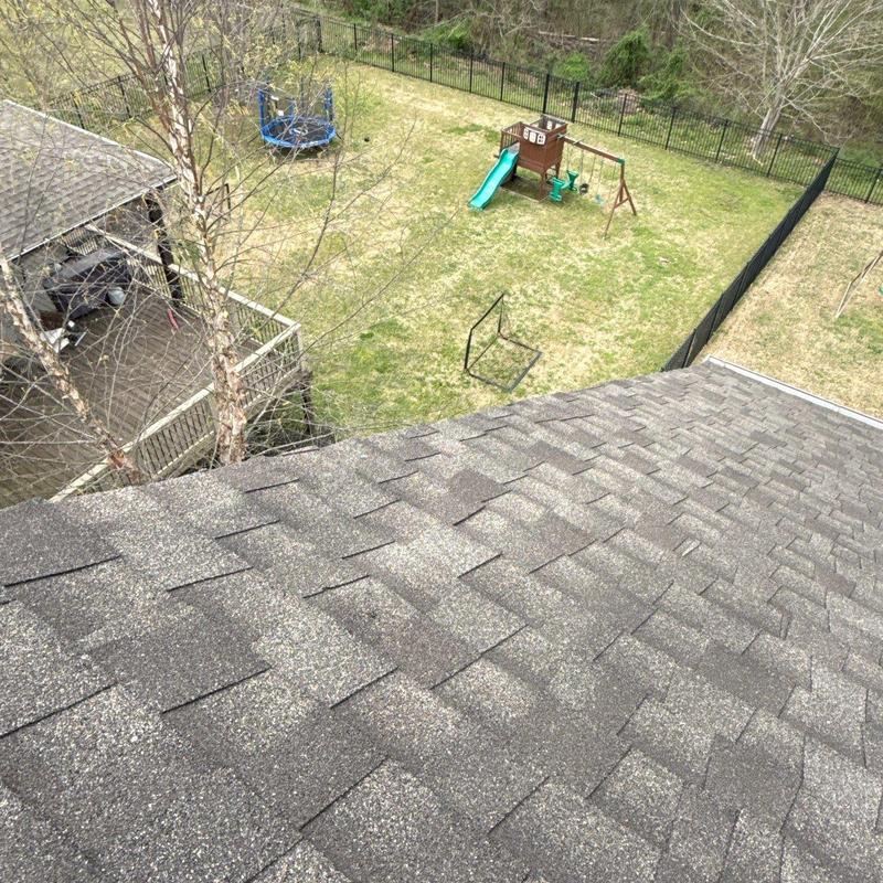 Asphalt shingle roof with hail damage in backyard view