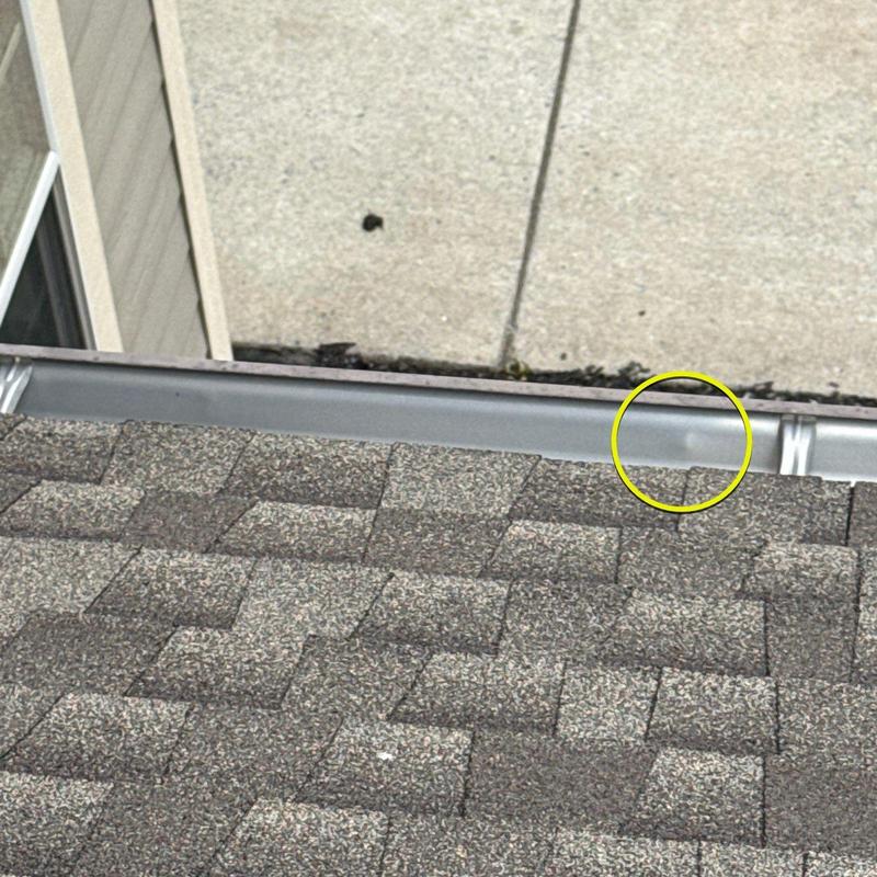 Asphalt shingles with hail damage near gutter edge