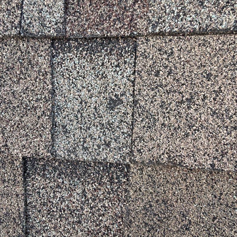 Asphalt shingle roof with hail damage close-up