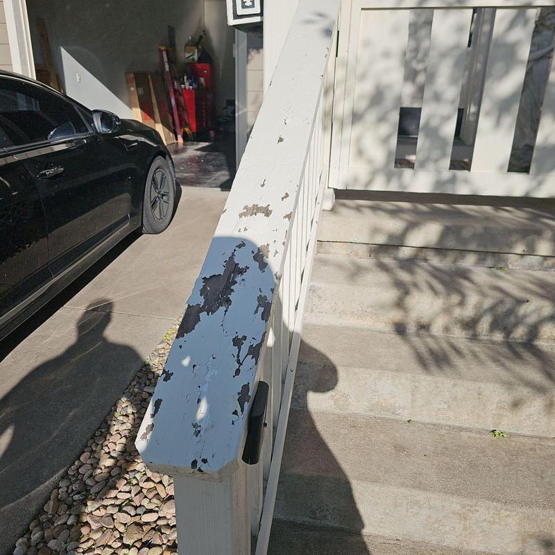 Wooden handrail with peeling white paint and damage Wooden handrail with peeling white paint and damage