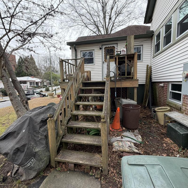 Wooden deck stairs and landing with weathered railing