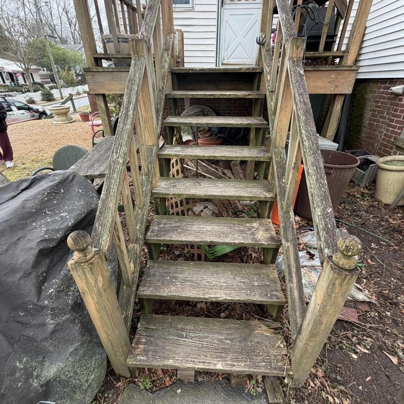 Wooden deck stairs with weathered railing and balusters