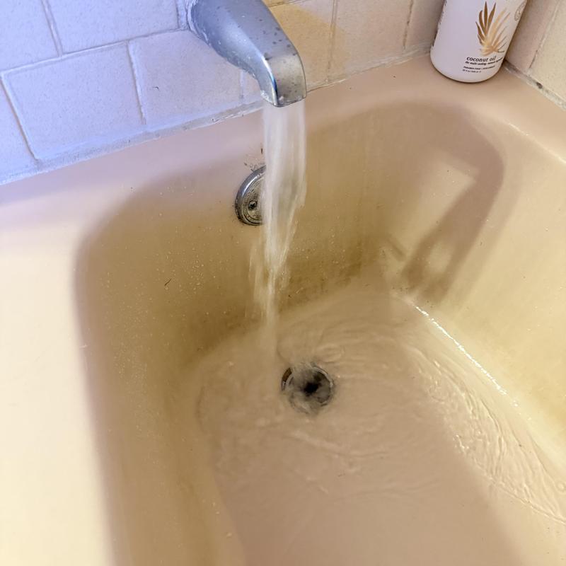 Bathtub drain with flowing water during clearing process
