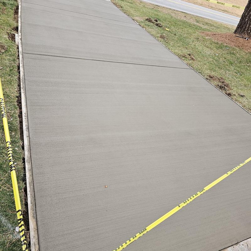 Concrete sidewalk with fresh curb and caution tape