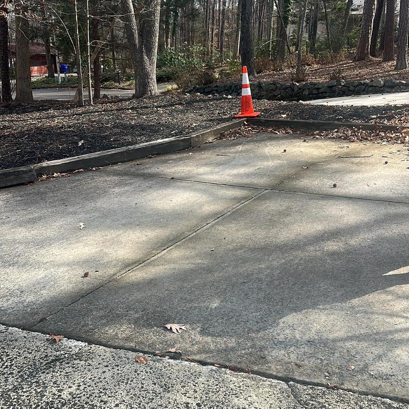 Concrete driveway with new curb and traffic cone