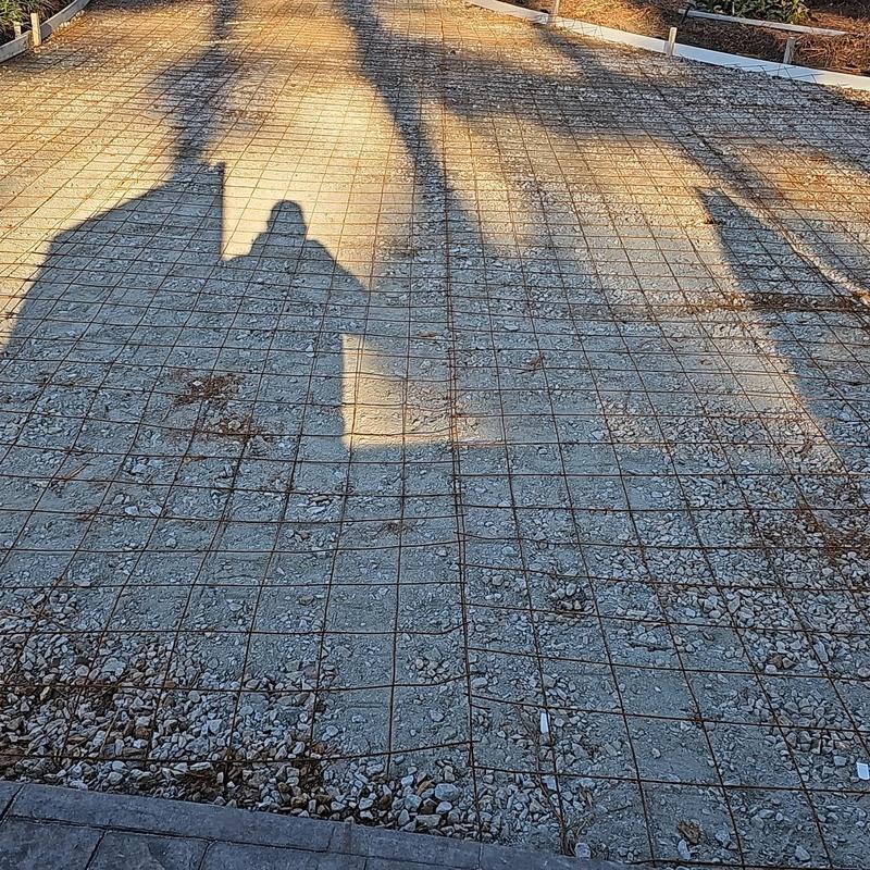 Concrete driveway wire mesh installation over gravel base