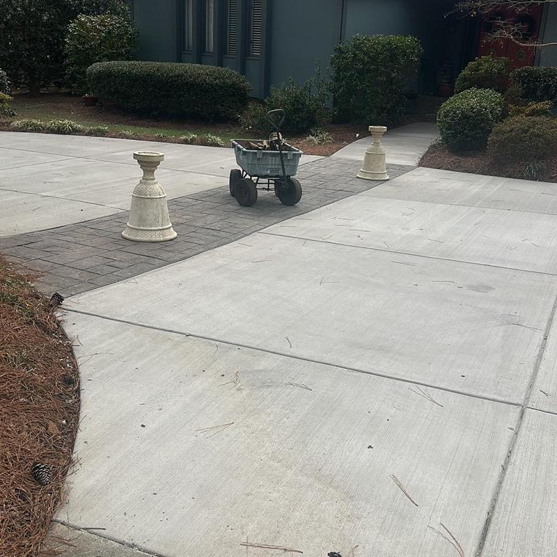 Concrete driveway with stamped concrete border and wheelbarrow